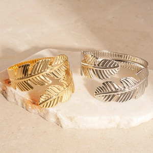Elegant gold and silver leaf-shaped metal napkin rings with fine leaf vein texture