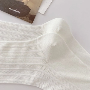Close-up of white breathable mesh texture and ribbed knit detail on cotton socks