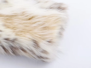 Detailed macro view of soft white and brown faux fur texture with high density fibers