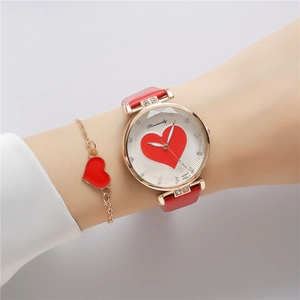 Close-up of women's rose gold watch with red heart dial and matching heart bracelet set