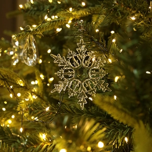Clear snowflake Christmas tree ornaments with glowing warm white LED light background