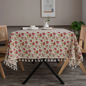 Detail view of cotton linen tablecloth with red rose pattern and decorative fringe edges