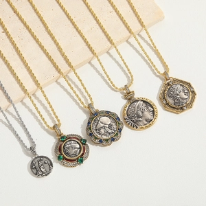 Detailed close-up of retro coin necklaces with colorful gemstones on a stone base