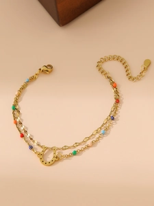 Close-up of double-layer gold horseshoe bracelet with colorful beads and lobster clasp