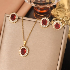 Elegant gold jewelry set with oval red zircon necklace earrings and ring on velvet