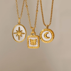 Dettaglio di collane placcate oro 18K con pendenti in conchiglia a stella, farfalla e luna