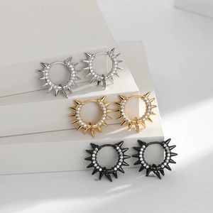 Macro shot of punk style spiked hoop earrings with inlaid diamonds in silver, gold and black