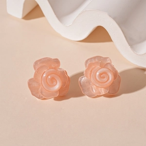 Detail view of pink resin rose petal earrings with elegant pearlescent finish