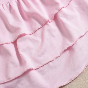 Detail of pink tiered ruffles with high-quality stitching on a knit mini skirt