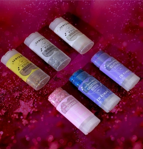 Close-up of six vibrant glitter sticks for face, hair, and body in festive colors
