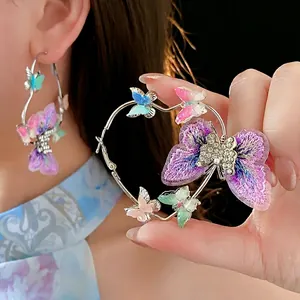 Exquisite silver hoop earrings featuring purple butterfly embroidery and sparkling rhinestones