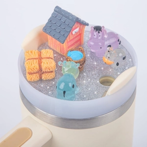 Detail of 40oz tumbler lid with a miniature farm scene featuring cows and a red barn
