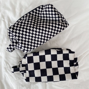Detail of checkered velvet makeup bag texture and handle with black and white waffle fabric