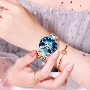Close-up of starry blue faceted glass dial and gold mesh strap watch for women