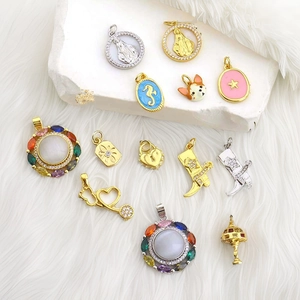 Macro shot of assorted luxury charms with colorful gemstones and enamel icons on plush