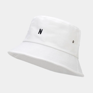 Détail d'un chapeau bob en coton blanc avec broderie de la lettre N et œillets métalliques