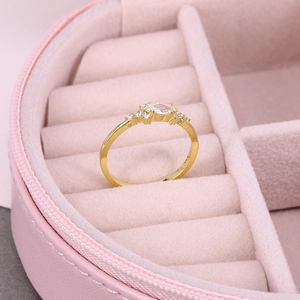 Macro view of a luxury gold ring with oval gemstone in a pink velvet jewelry box