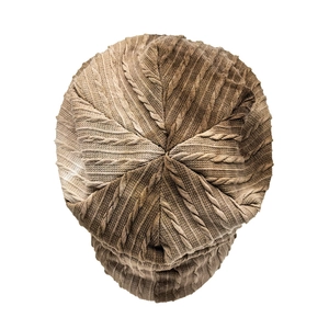 Macro detail of tan cable knit beanie showing intricate radial pattern and warm texture