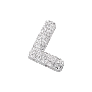 Macro detail of silver L-shaped pendant with cubic zirconia inlay on white background