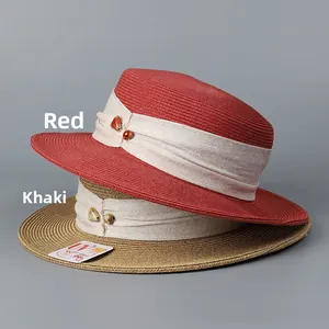 Detailed texture of red and khaki wide-brim woven straw hats with UV 99% protection tag