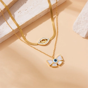Detail of double-layer gold necklace with evil eye pendants and rhinestone accents