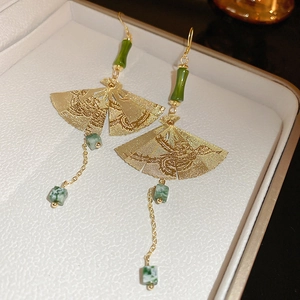 Detail of bamboo joint earrings with gold fans and green pearls in Chinese style