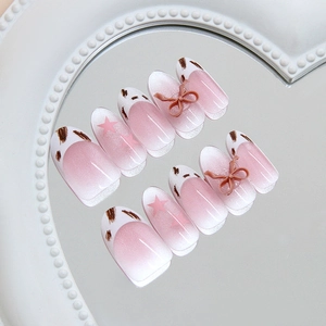 Pink cat-eye press-on nails with 3D bows and star patterns on heart mirror tray