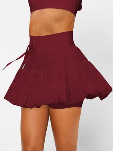 Detail of burgundy high-waisted ruffled mini skirt with adjustable drawstring and layered hem