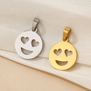 Macro shot of 18K gold and silver smiley face heart eye pendants on silk fabric