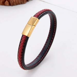 Detail of black braided leather bracelet with red stitching and gold magnetic clasp