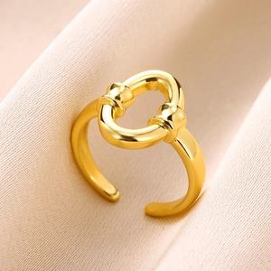 Detail of gold-plated open ring featuring a smooth oval interlocking buckle design