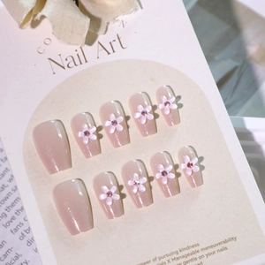 Sparkly pearlescent pink press-on nails with 3D floral designs and small pink rhinestones