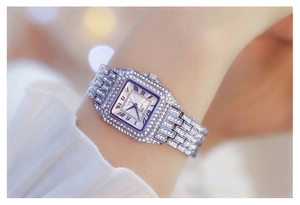 Close-up of a silver square watch with crystals and Roman numerals on a female wrist