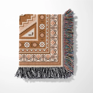 Detail of bohemian knit blanket with geometric patterns and colorful tassels