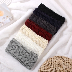 Braided knit ear warmer headbands in seven colors on a white plush background