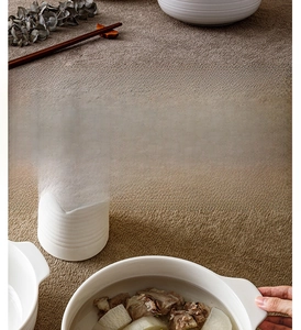 Close-up of cream ceramic soup bowl with handles and heart relief textured mug
