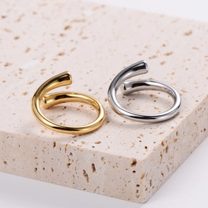 Detail of twisted gold and silver titanium steel open rings on a stone display