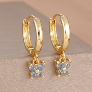 Vue macro de boucles d'oreilles papillon plaquées or 18 carats avec zircons bleus