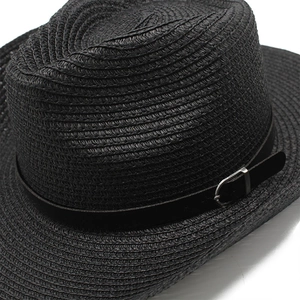 Detailed shot of black straw cowboy hat featuring a leather band and metal buckle