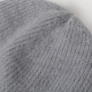 Macro shot of grey winter knit beanie featuring thick fluffy texture and ribbed stitching