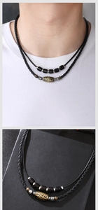 Detail of woven black wax cord necklace featuring antique bronze totem bead and black cubes