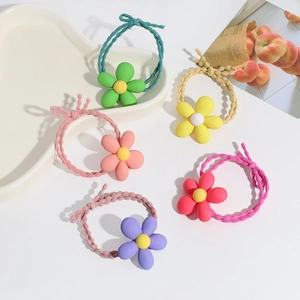 Close-up of five colorful candy-colored flower hair ties on a ceramic tray set