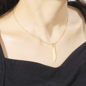 Elegant gold titanium steel necklace with curved bar pendant shown on model's neckline
