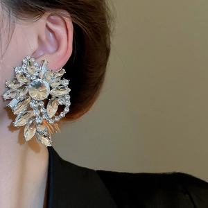 Close-up of sparkling floral cluster earrings with crystals on a model for gala events
