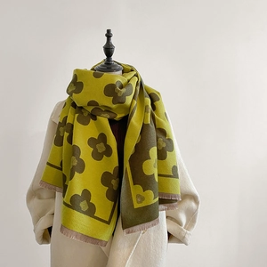 Detail of winter scarf showing mustard green knit texture and brown floral pattern