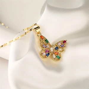 Detail of butterfly pendant with colorful gemstones on white silk background
