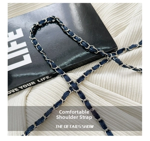 Detail of vintage-style silver metal chain strap interwoven with dark blue denim fabric