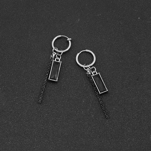 Detailed macro view of long tassel earrings with black gemstones and silver chains
