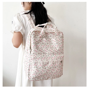 Floral canvas backpack for students worn by a model against a clean white wall