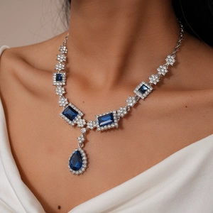 Dettaglio della collana con pietre blu scuro a goccia e piccoli zirconi brillanti